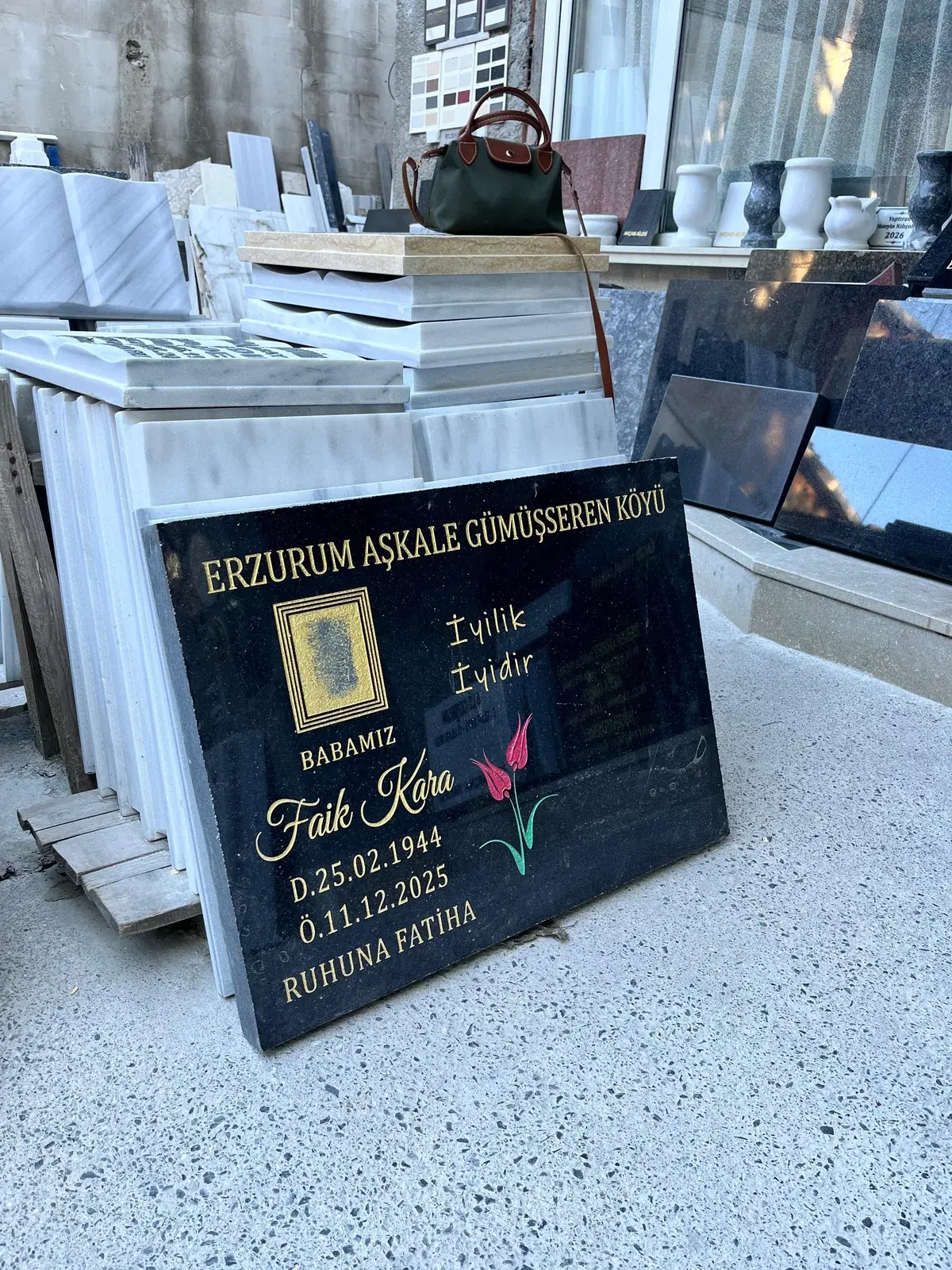 Altın renk yazı ve çiçek motifi bulunan siyah granit baştaşı