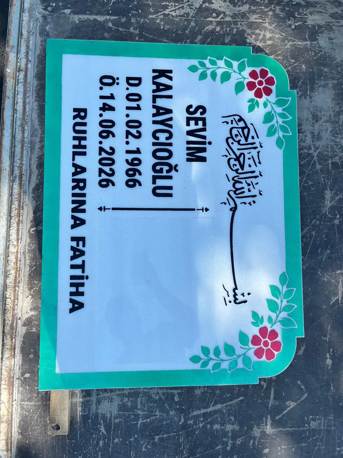Yeşil çerçeve ve renkli çiçek motifleri bulunan mermer baştaşı