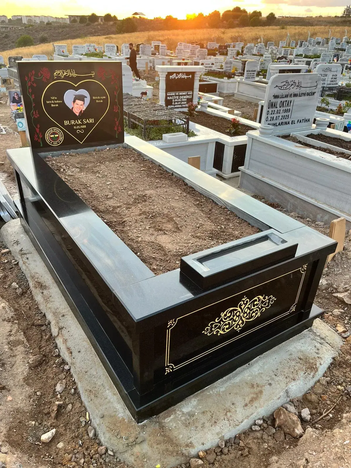 Siyah granit yüzey ve kontrollü altın motiflerle hazırlanan mezar